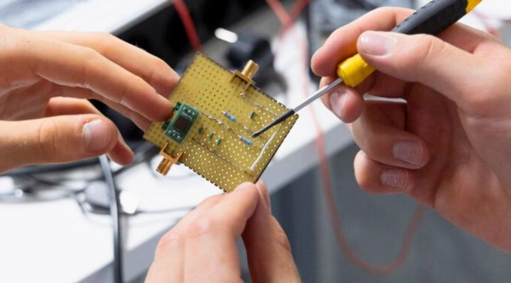 dues persones treballant amb un chip electrònic